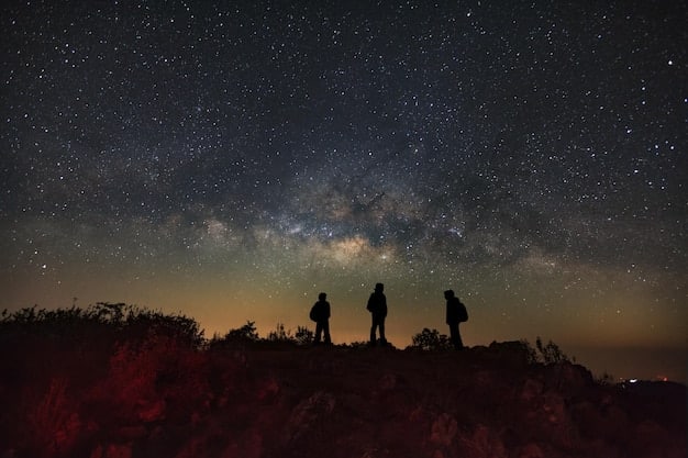 A wide-angle shot of a group of people using telescopes under a starry sky in a dark sky park, with the Milky Way visible overhead.