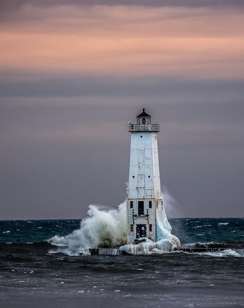 A picturesque lighthouse on the Outer Banks, North Carolina, with crashing waves and dramatic clouds in the background.