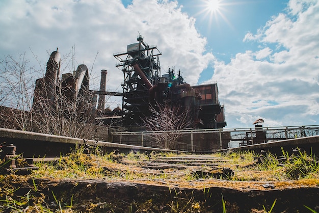 The rusted remains of mining equipment in a ghost town, set against a backdrop of barren hills, visually representing the rise and fall of the mining industry.