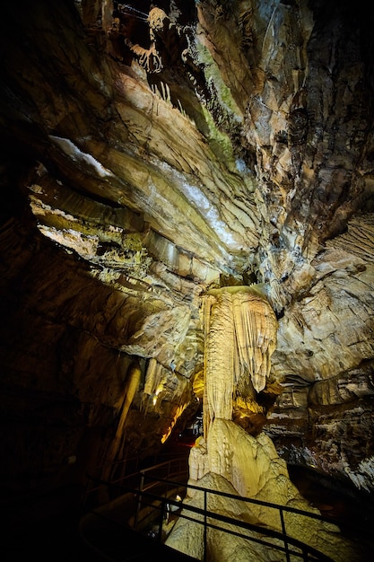 An interior view of Luray Caverns in Virginia, showing its stunning array of stalactites and stalagmites reflected in the still waters of the Dreaming Lake. The lighting enhances the natural colors and textures of the formations, creating a serene and magical atmosphere.