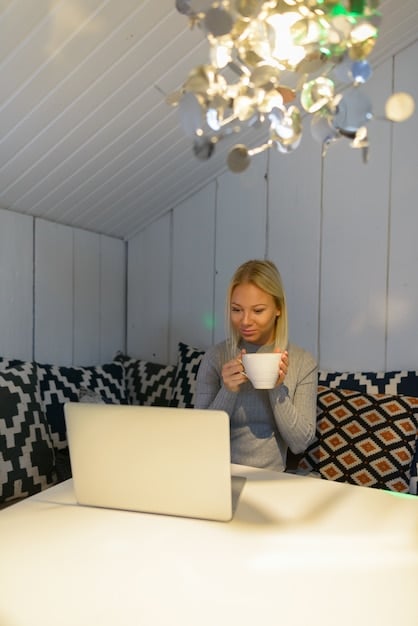A person working on a laptop in a quiet corner of an airport lounge, with a cup of coffee and a charging station nearby. The atmosphere is relaxed and conducive to productivity.