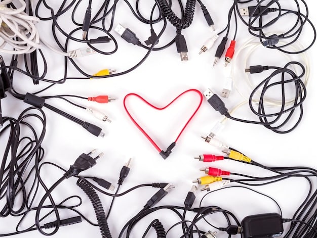A tangled mess of charging cables, various universal adapters, and several electronic devices spilling out of a travel bag, symbolizing disorganization and overpacking of gadgets.