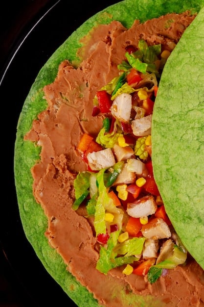 A close-up shot of a tlayuda, a large, crispy tortilla topped with beans, cheese, lettuce, avocado, salsa, and your choice of meat, showcasing the variety and deliciousness of Oaxacan cuisine.