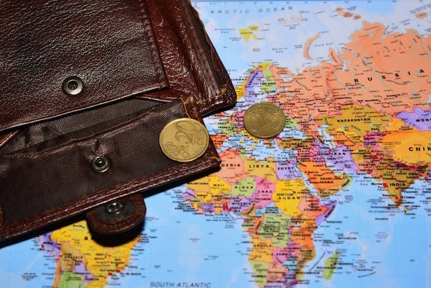 A world map made of small coins, with a blurred passport in the foreground, symbolizing global travel expenses and financial considerations.