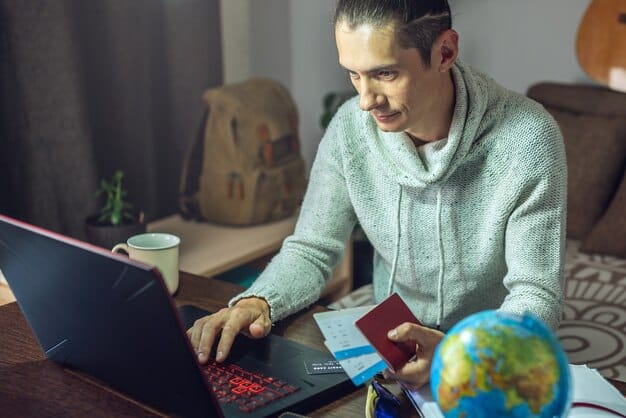 A person using a laptop to compare different travel insurance policies, with a credit card nearby, indicating the process of choosing and purchasing travel insurance online.